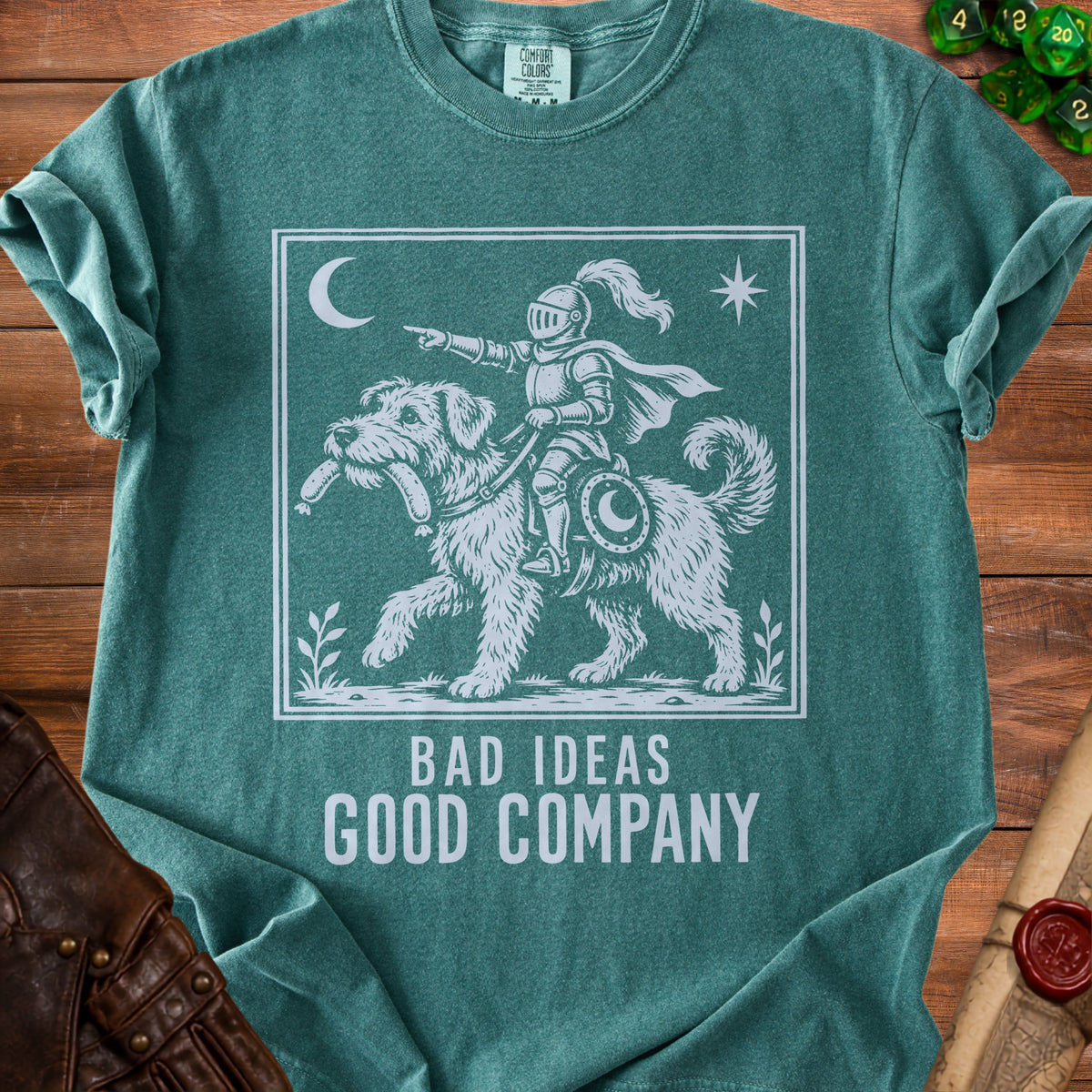 Green t-shirt with white graphic of knight riding a dog, text "BAD IDEAS GOOD COMPANY".