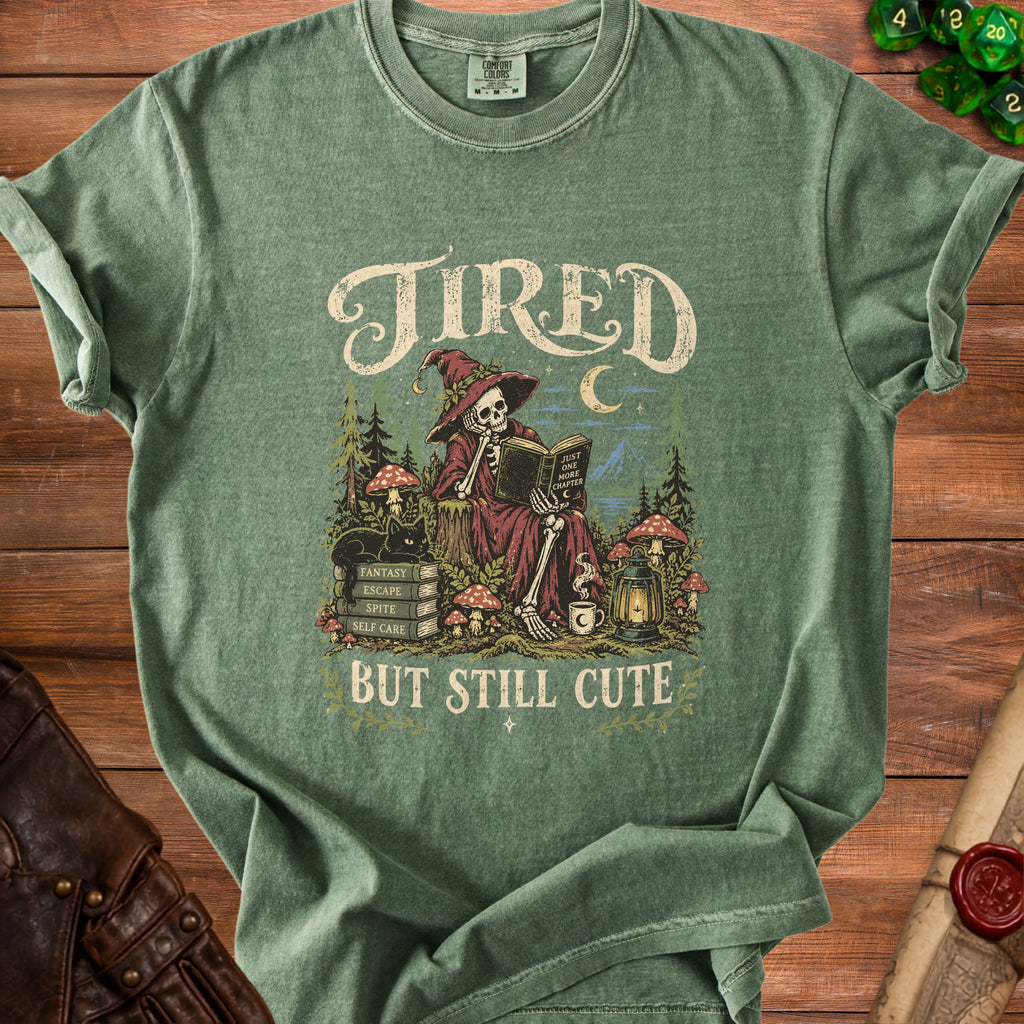 Skeleton witch reading "Just one more chapter" on a t-shirt that says "Tired but still cute".