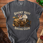 Short Rest Social Club t-shirt with cartoon dogs in fantasy attire gathered at a table.