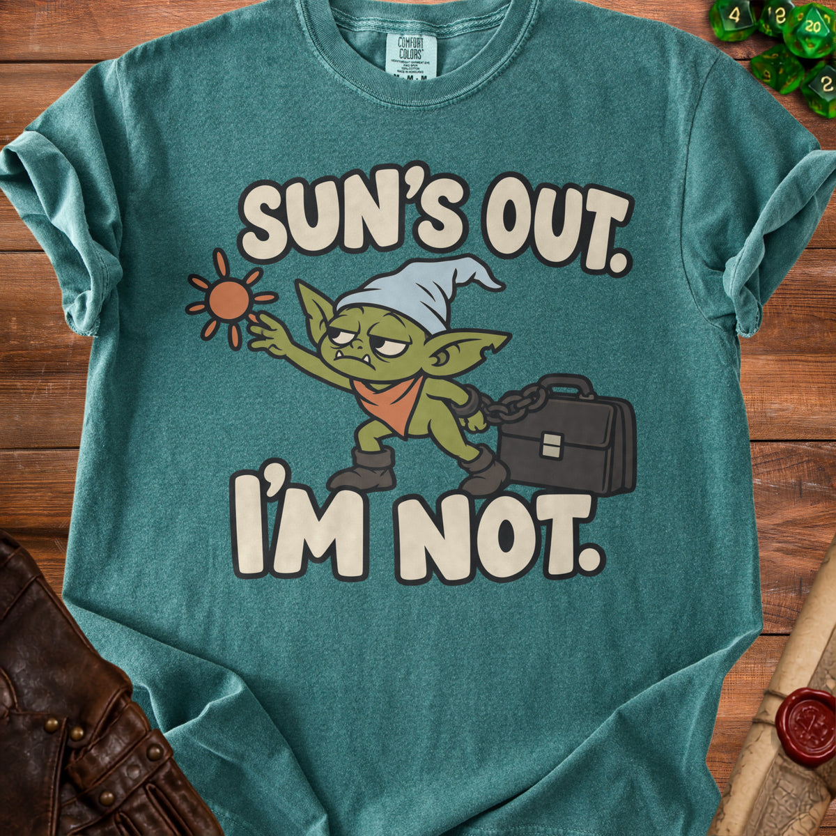 Green t-shirt with a cartoon goblin and the text "Sun's Out. I'm Not."