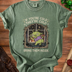 Green t-shirt with a cartoon goblin character inside a window and the text "If you're cold they're cold bring them inside".