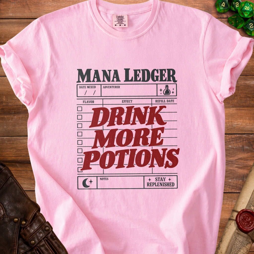 Pink t-shirt with "Mana Ledger" and "Drink More Potions" text.