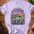 Lavender t-shirt with "Off in Fantasy Land" text and cartoon goblin graphic.