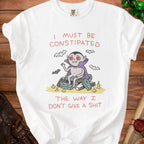 White t-shirt with a cartoon vampire on coffins and bats, stating "I must be Constipated The way I Don't Give a Shit".