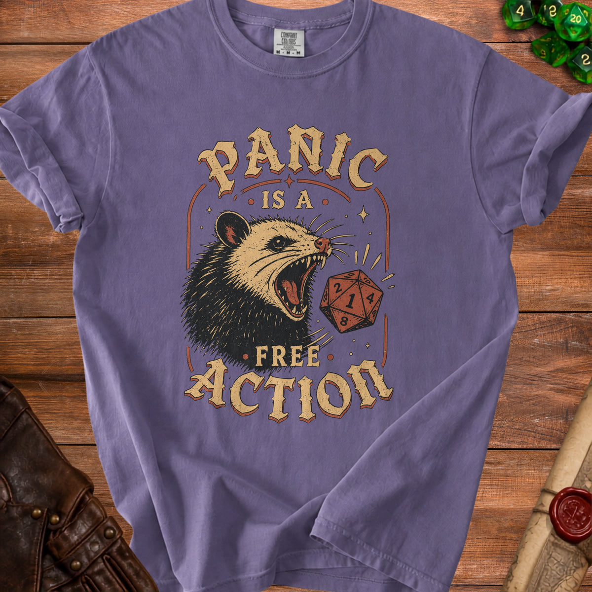 Purple t-shirt with opossum and dice graphic, "Panic is a free action" text.