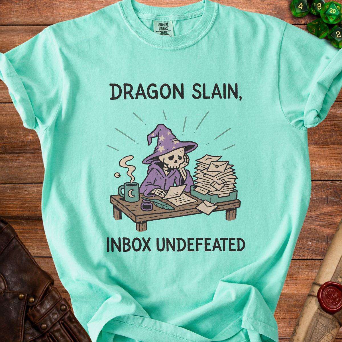 Teal t-shirt with a skeleton wizard graphic and text "Dragon Slain, Inbox Undefeated".