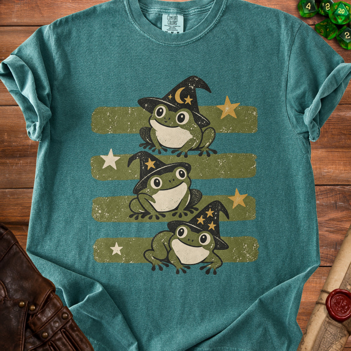 Three cartoon frogs wearing witch hats with moons and stars on a green striped background.