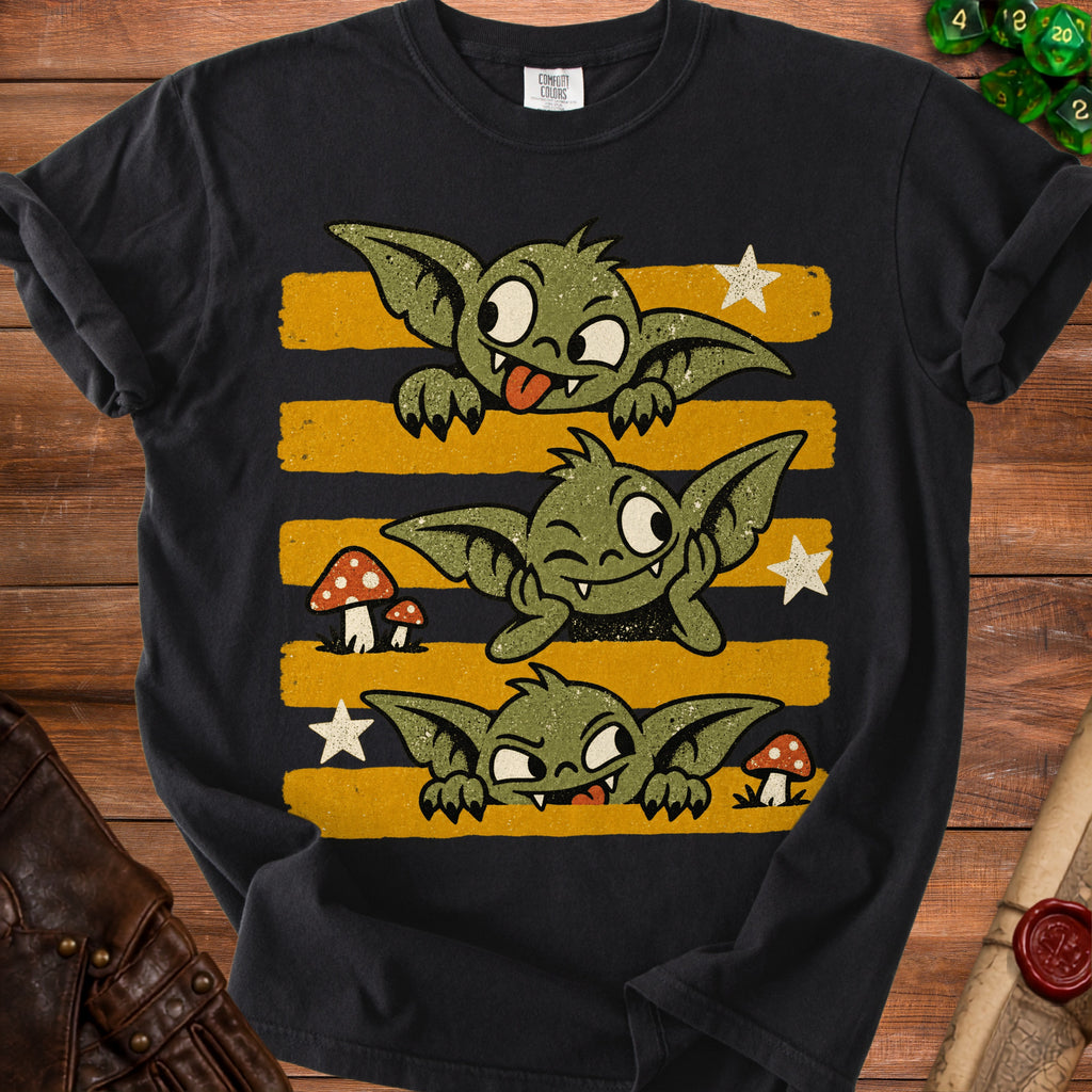 Black t-shirt featuring three cartoon goblins with yellow and black striped background.