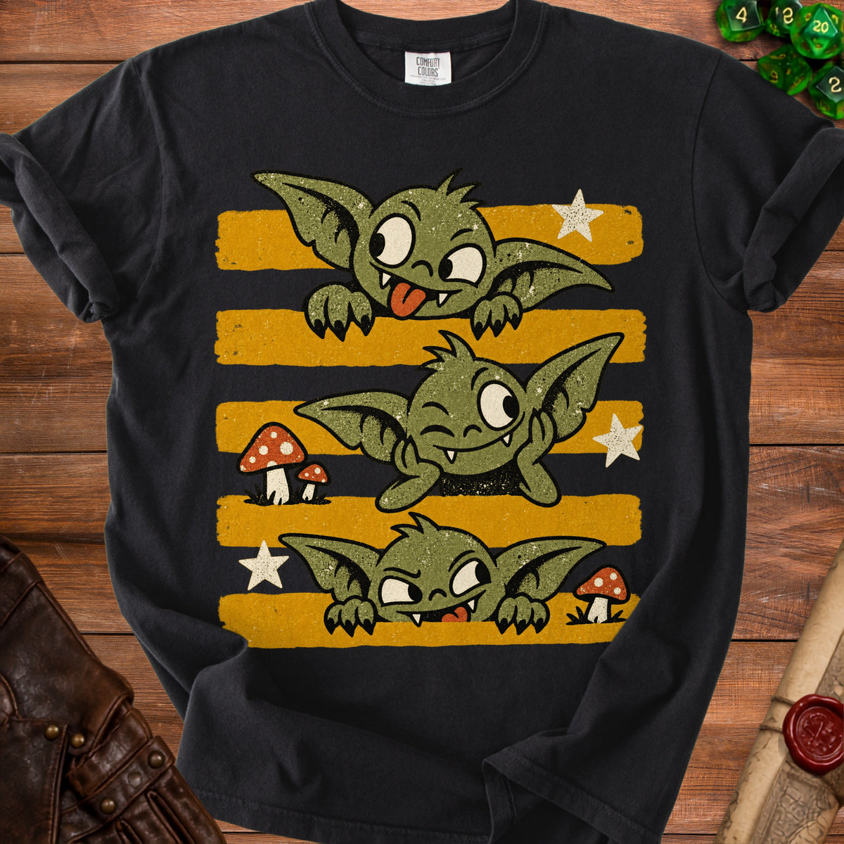 Black t-shirt featuring three cartoon goblins with yellow and black striped background.