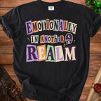 Black t-shirt with "Emotionally In Another Realm" text and night sky graphic.