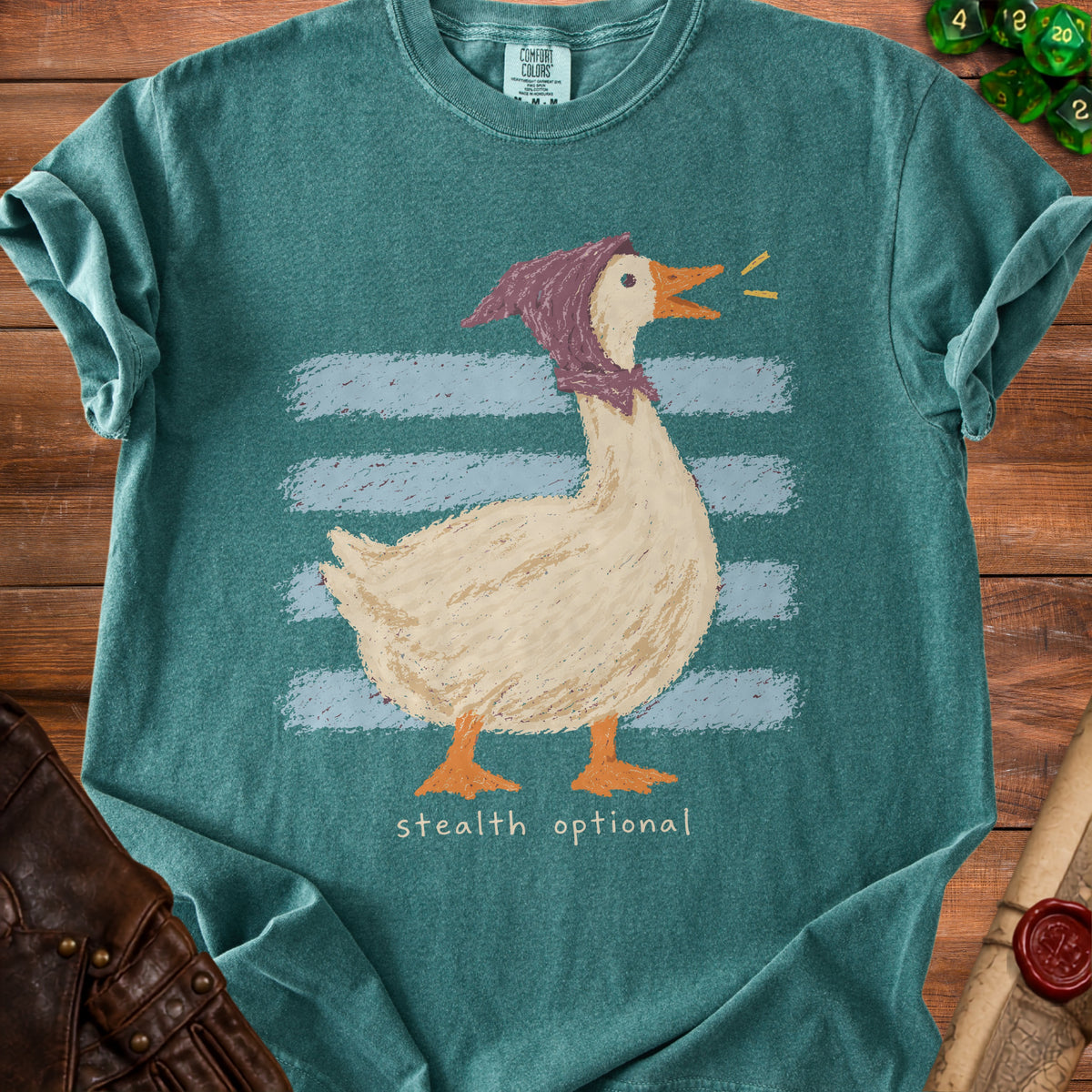 Green t-shirt with a drawing of a goose in a purple scarf and the text "stealth optional".
