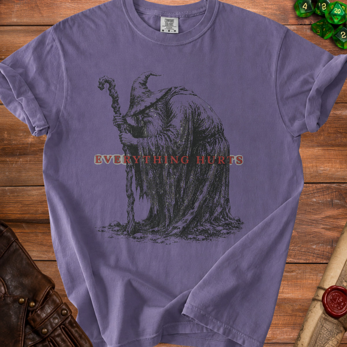 Purple t-shirt with a black and white illustration of a wizard and the text "EVERYTHING HURTS".