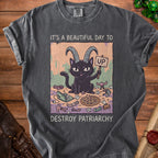 Dark grey t-shirt with a graphic of a black cat with horns holding an "UP" sign and the text "Destroy Patriarchy".