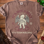 Brown t-shirt with Cthulhu graphic and text "IT'S NOT A CULT IT'S TEAM BUILDING".
