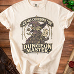An off-white t-shirt featuring a fantasy graphic with a goblin wizard, a d20 die, and the text Chaos Coordinator Dungeon Master.
