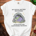 White t-shirt with "My Social Battery Recharges In Isolation And Questionable Decisions" text and goblin art.