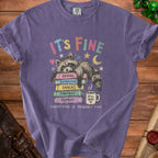 Purple t-shirt with a raccoon on books and text "IT'S FINE EVERYTHING IS PROBABLY FINE".