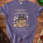 Purple t-shirt with black cat in a box and text "PROBABLY OVERTHINKING BUT AT LEAST I HAVE A BOX".