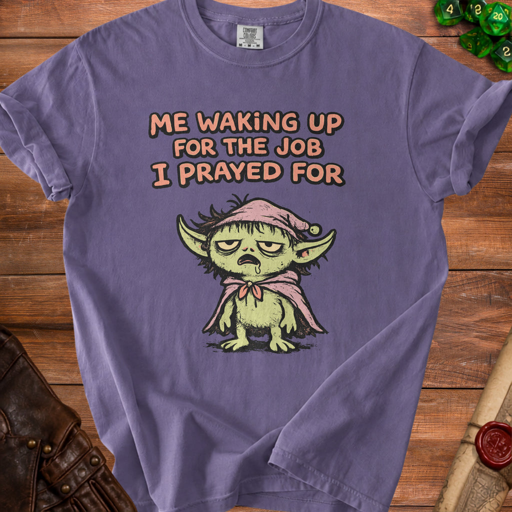 Purple t-shirt with cartoon goblin graphic and text "Me waking up for the job I prayed for."