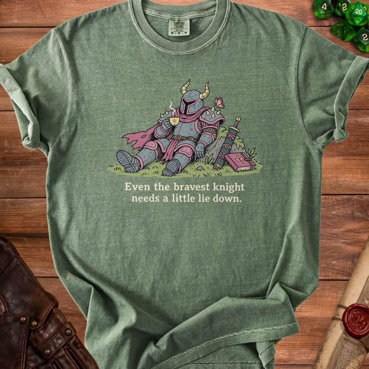 Green t-shirt with illustration of a knight drinking tea, text "Even the bravest knight needs a little lie down."