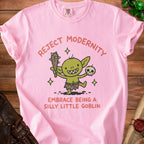 Pink t-shirt with "Reject Modernity Embrace Being A Silly Little Goblin" and a goblin illustration.