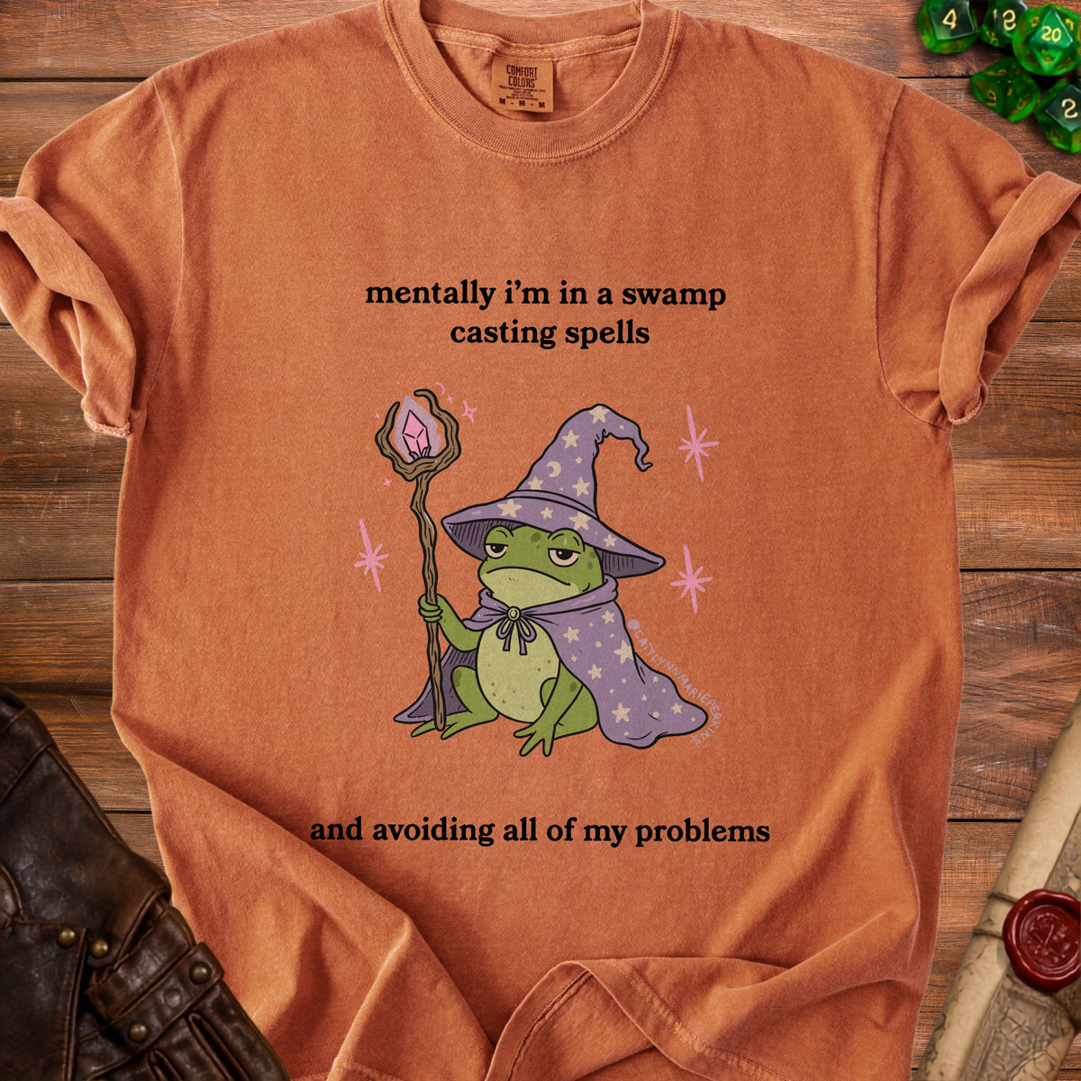 Orange t-shirt with a frog wizard graphic and text.