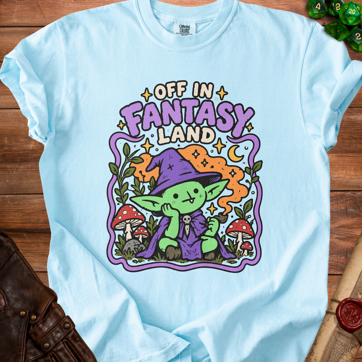 Light blue t-shirt with "Off in Fantasy Land" graphic of a gnome with a pipe.