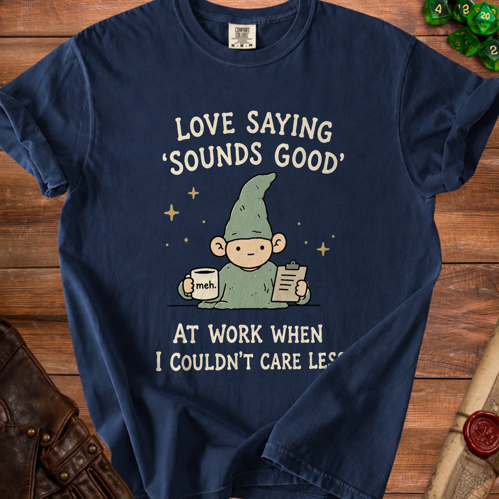 Dark blue t-shirt with a gnome holding a coffee mug and clipboard. Text reads "LOVE SAYING 'SOUNDS GOOD' AT WORK WHEN I COULDN'T CARE LESS".
