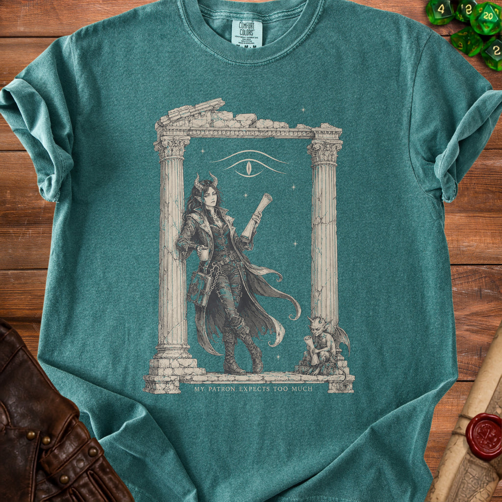 Green t-shirt with fantasy art of a horned woman and text "MY PATRON EXPECTS TOO MUCH".