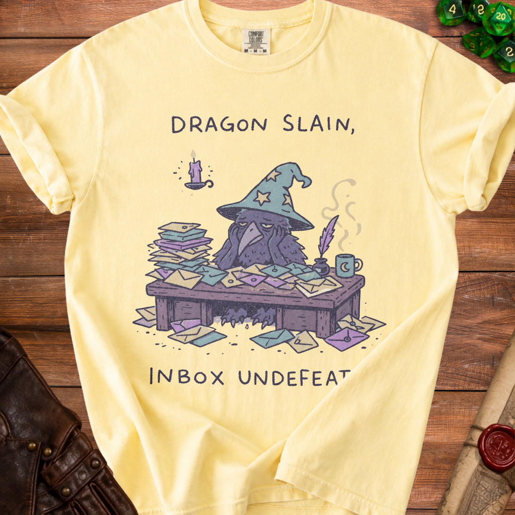 Yellow t-shirt with illustration of a crow wizard overwhelmed by mail, "Dragon Slain, Inbox Undefeated" text.