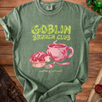 Green t-shirt with "Goblin Brunch Club cutlery optional" and illustration.