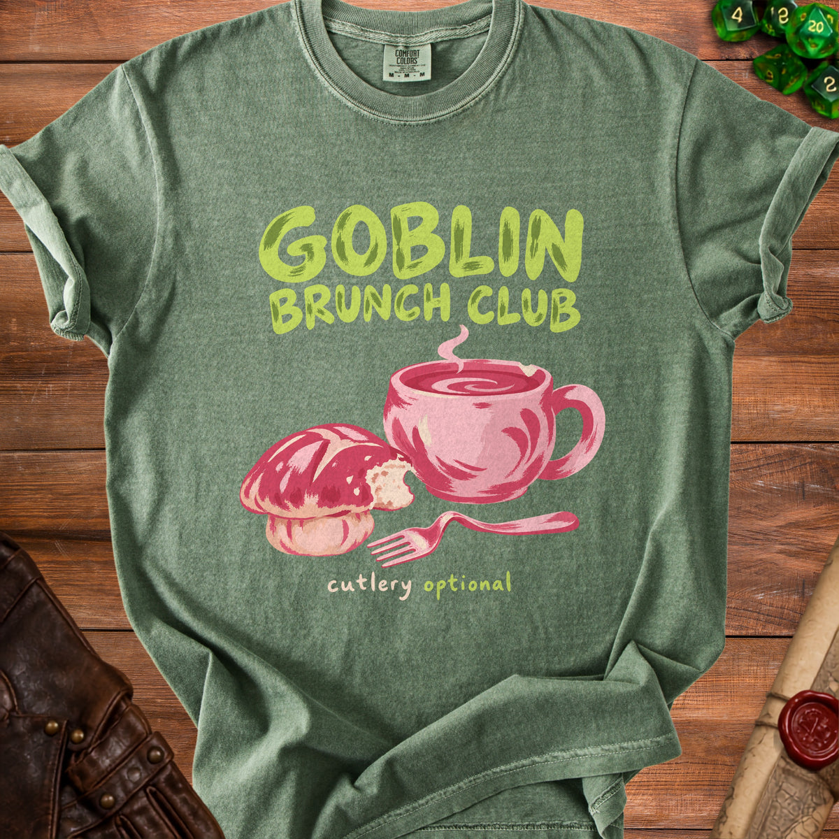 Green t-shirt with "Goblin Brunch Club cutlery optional" and illustration.