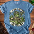 Blue t-shirt with "Touch Grass Cast Spells" and a forest creature graphic.
