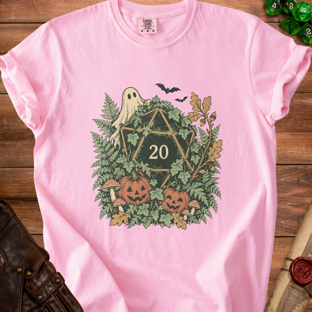 Pink t-shirt with D20 dice, ghost, pumpkins, bats, mushrooms, and foliage graphic.