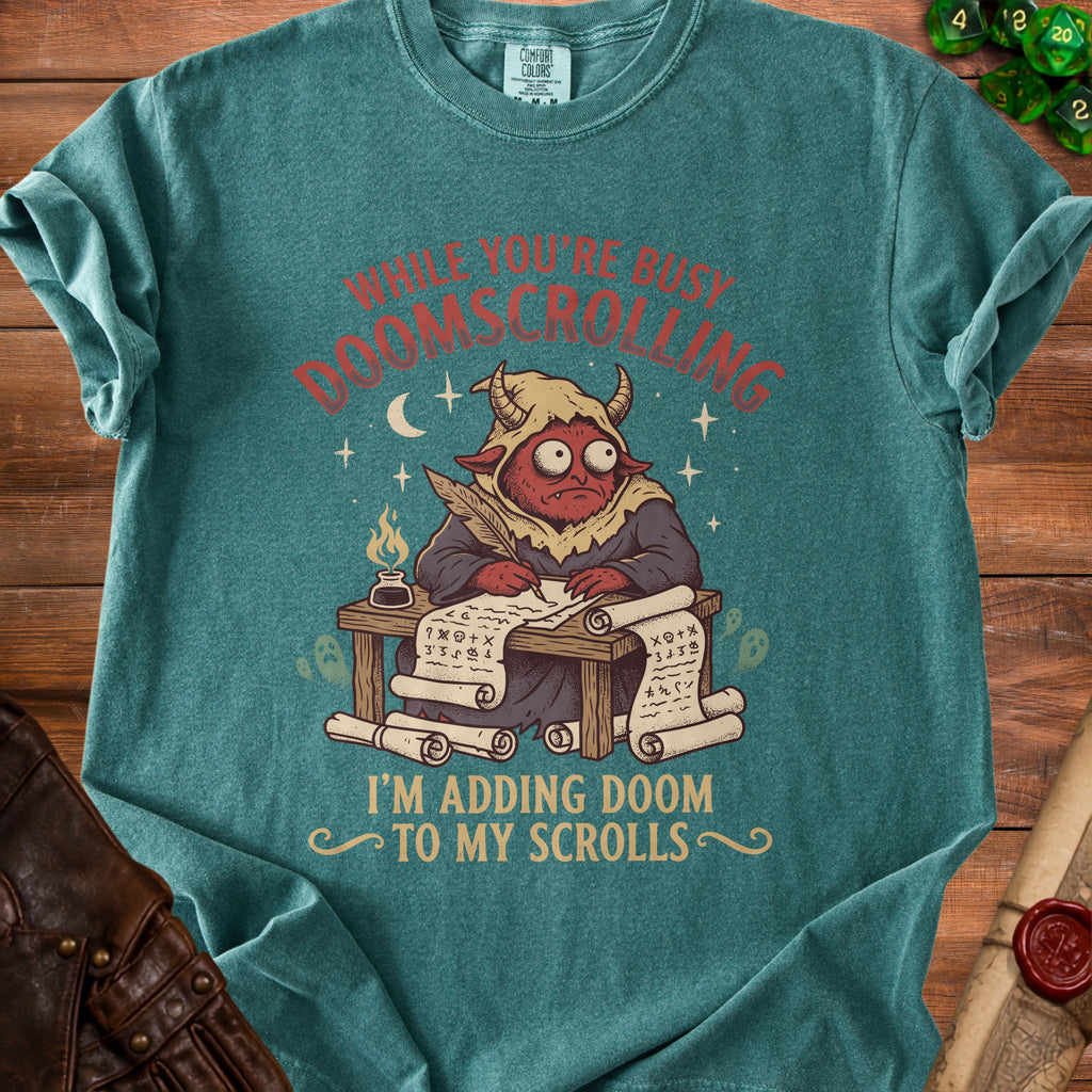 Teal t-shirt with a red devil writing "While you're busy doomscrolling I'm adding doom to my scrolls."