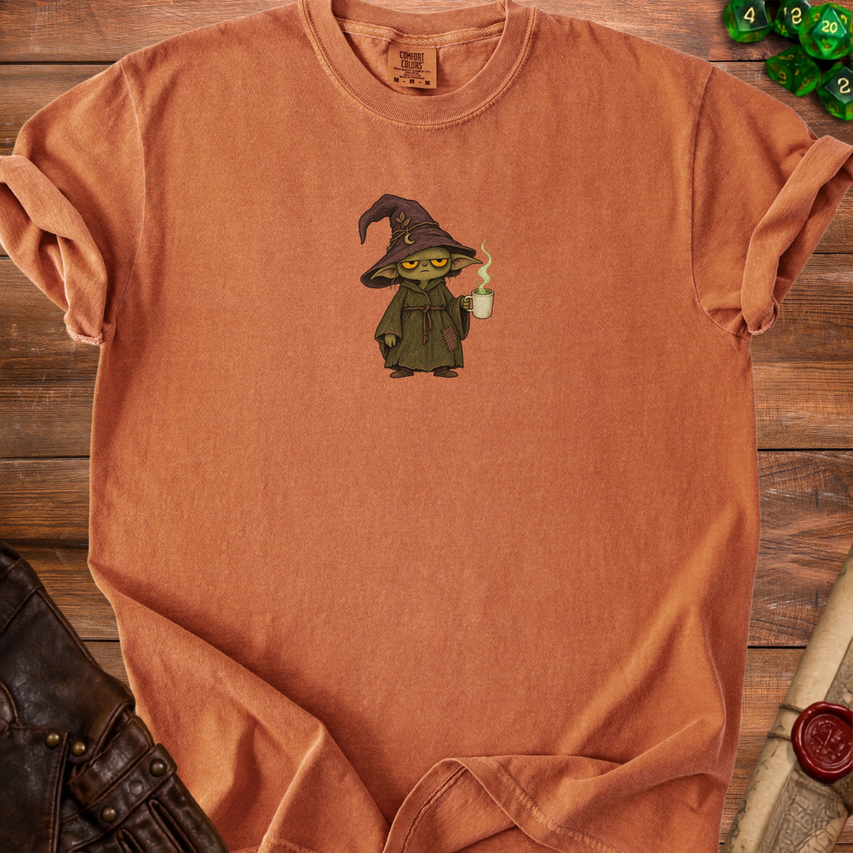 T-shirt with a grumpy wizard character holding a steaming mug.
