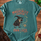 Teal t-shirt with a vintage wizard graphic and the text "Things Don't Magically Happen. Create Your Own Luck."