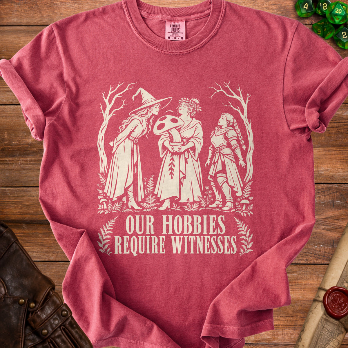 T-shirt with cream graphic of three women and text "OUR HOBBIES REQUIRE WITNESSES".