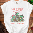 A white t-shirt featuring a graphic of three green female goblins and the text "God forbid women have hobbies."
