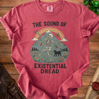 Red t-shirt with skeleton, mountain, rainbow, black cat, butterflies, and text "The Sound of Existential Dread".
