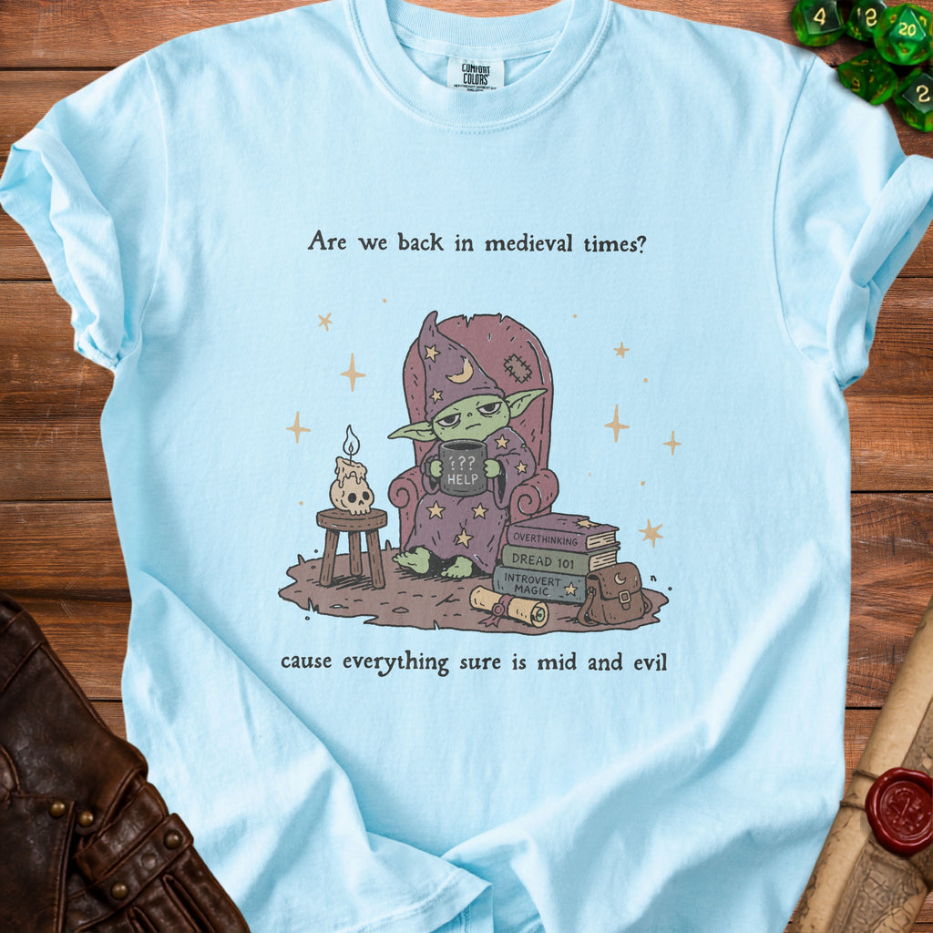 Light blue t-shirt with medieval-themed graphic and text: "Are we back in medieval times? cause everything sure is mid and evil."