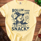 Yellow t-shirt with a corgi wizard graphic and text "Rollin' Through Life Critical Snacks".