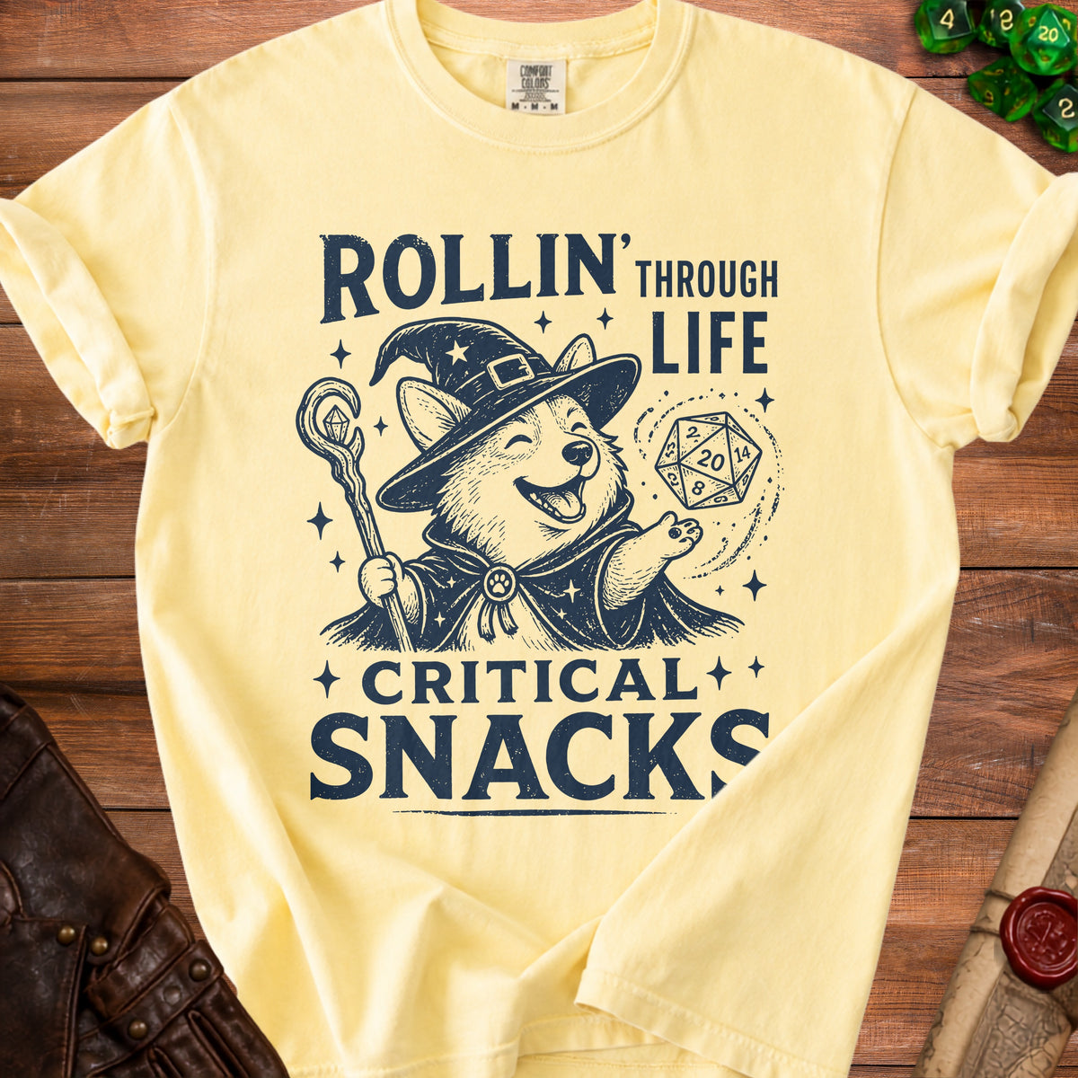 Yellow t-shirt with a corgi wizard graphic and text "Rollin' Through Life Critical Snacks".