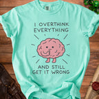 Mint green t-shirt with "I Overthink Everything And Still Get It Wrong" text and a brain graphic.
