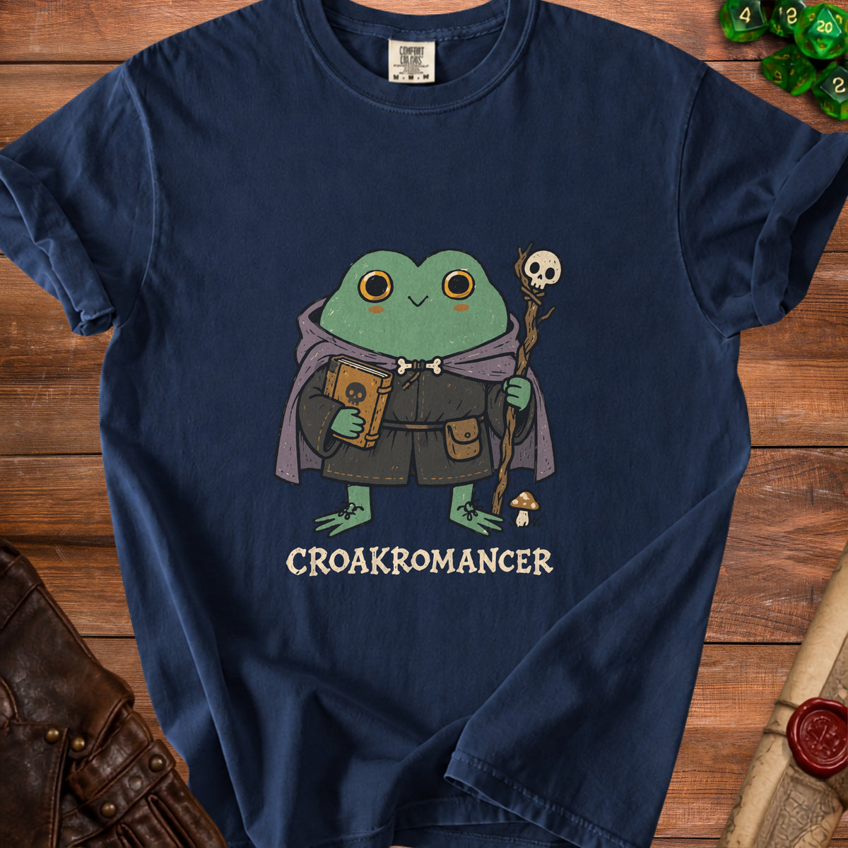 T-shirt with a frog wizard holding a book and staff, text reads CROAKROMANCER.