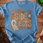 Blue t-shirt with "Side Quests" graphic, dice, lantern, and map.