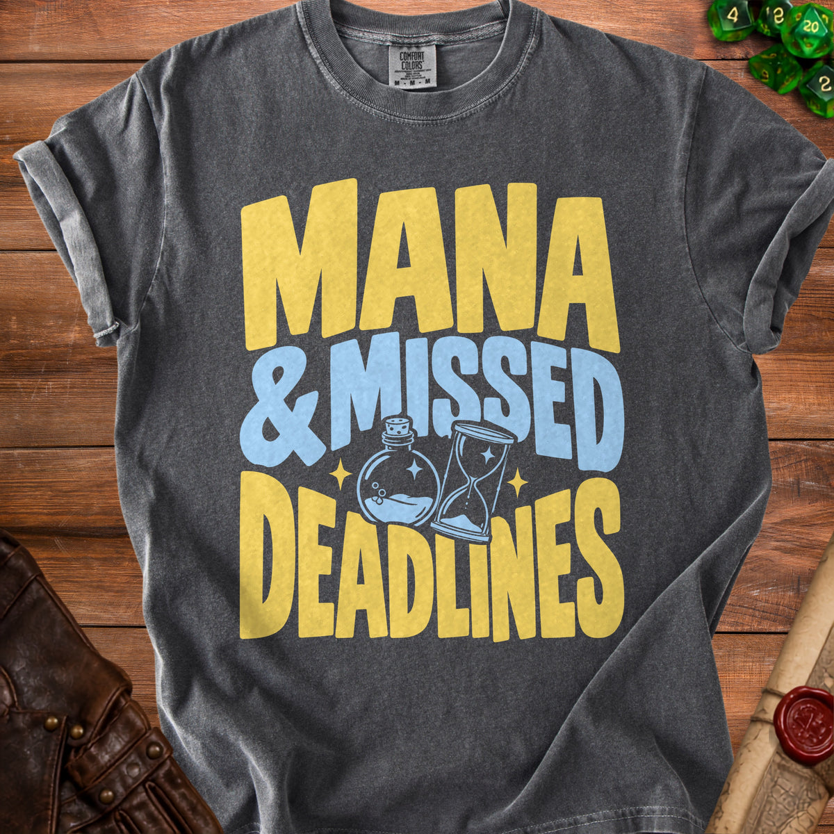 Dark gray t-shirt with yellow and blue text "Mana & Missed Deadlines".