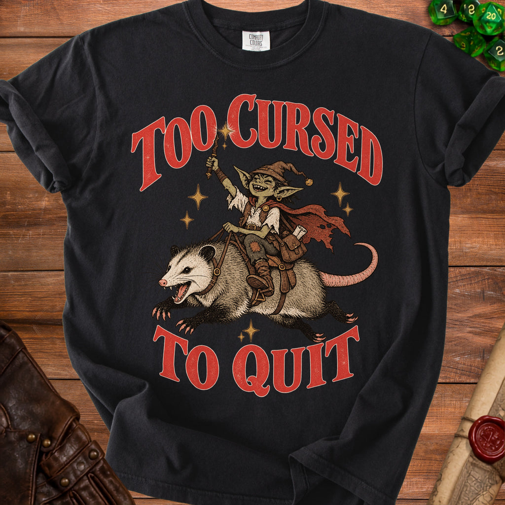 Black t-shirt with red text "TOO CURSED TO QUIT" and goblin riding a possum.
