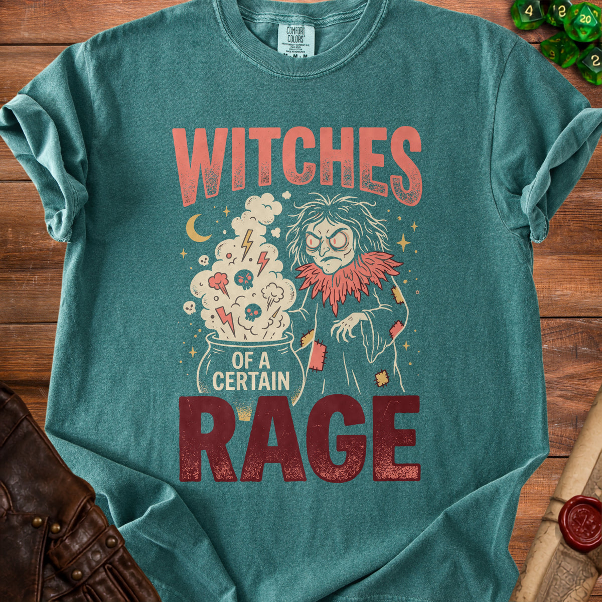 Teal shirt with "Witches of a Certain Rage" graphic featuring a witch and cauldron.