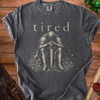 Charcoal Comfort Colors t-shirt with text "tired" and graphic of a knight sitting.